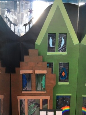 photo of an art installation in North Berwick which is an image of houses with decorations in the windows, including a rainbow